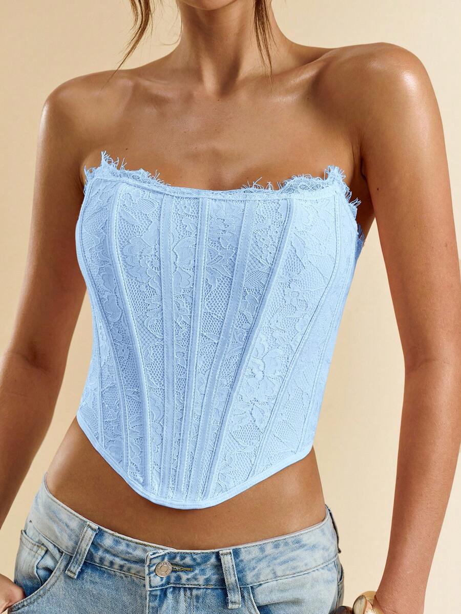 Women's strapless bustier crop top with contrast lace, lace-up detail, and an asymmetric hem in a slim-fit satin finish.