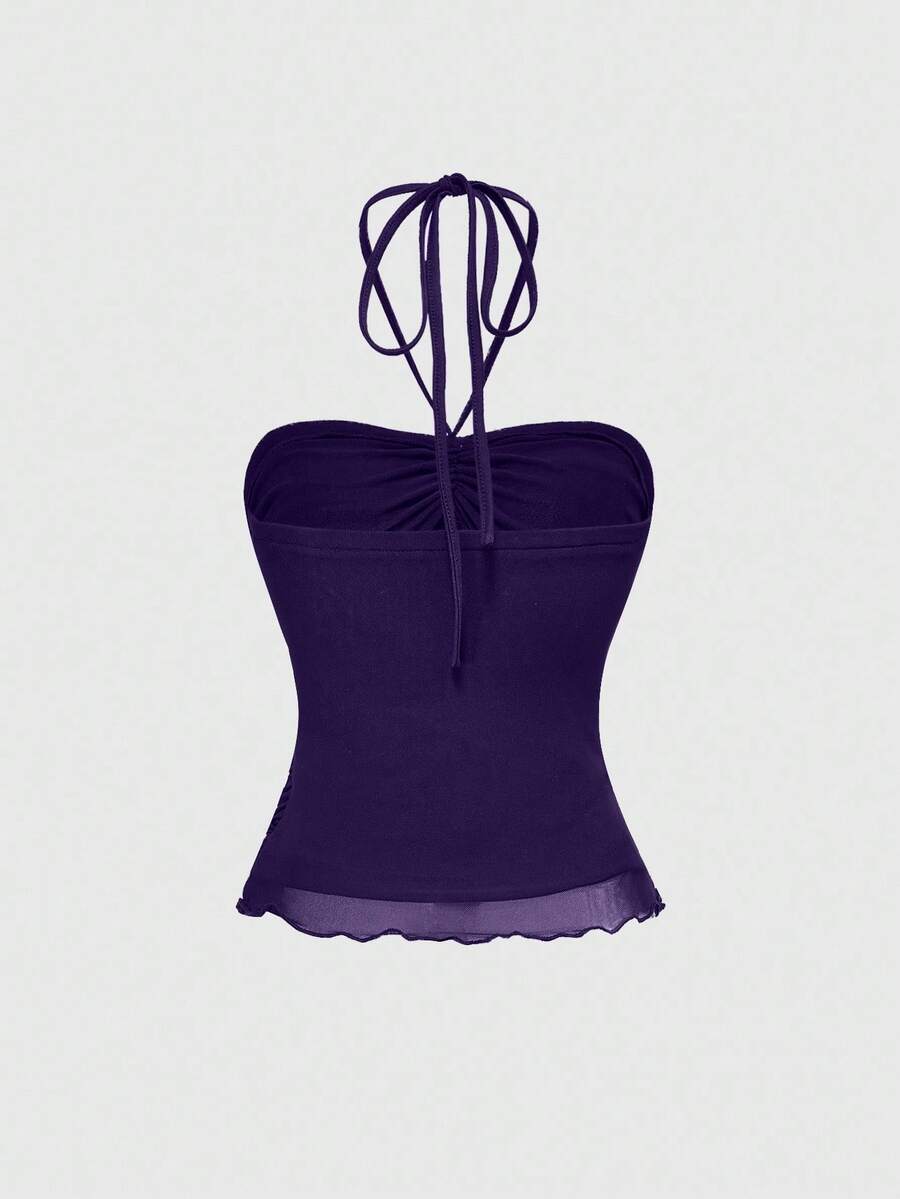 Women's black halter crop top featuring a backless cut, front ring detail, knot accent, asymmetrical hem, and high-stretch mesh fabric.