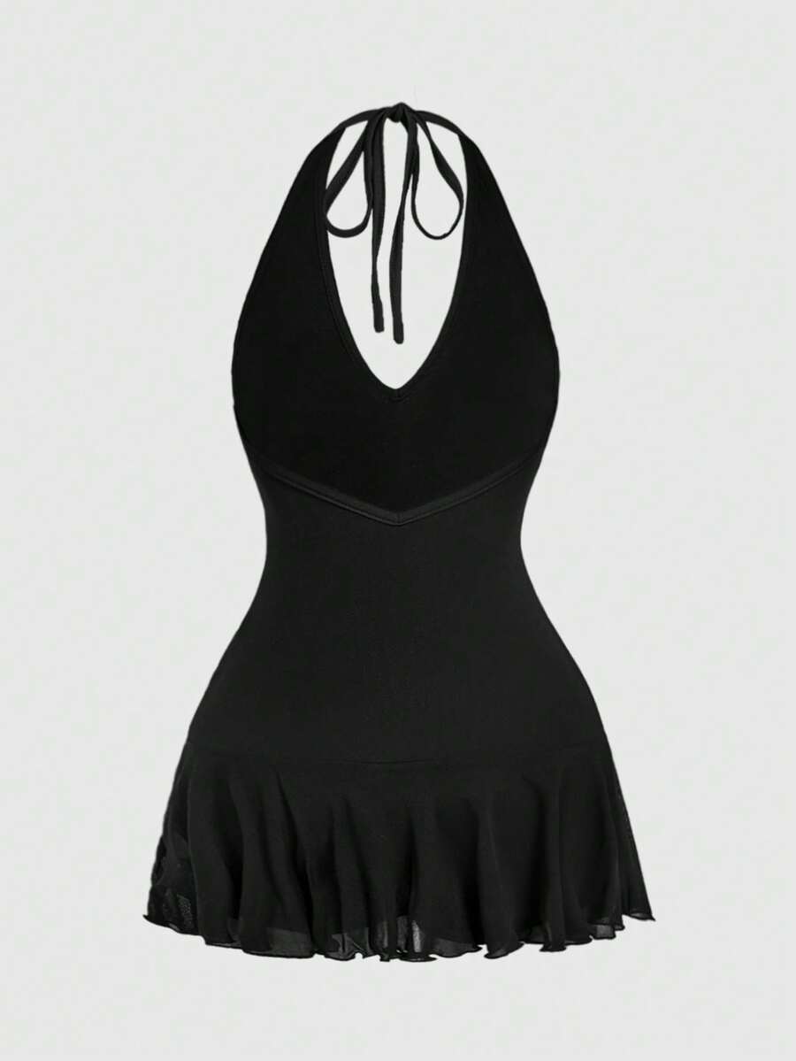 Women's black Y2K backless mesh mini dress featuring an asymmetrical neckline, tie-back knot detail, and a slim fit flared A-line silhouette.