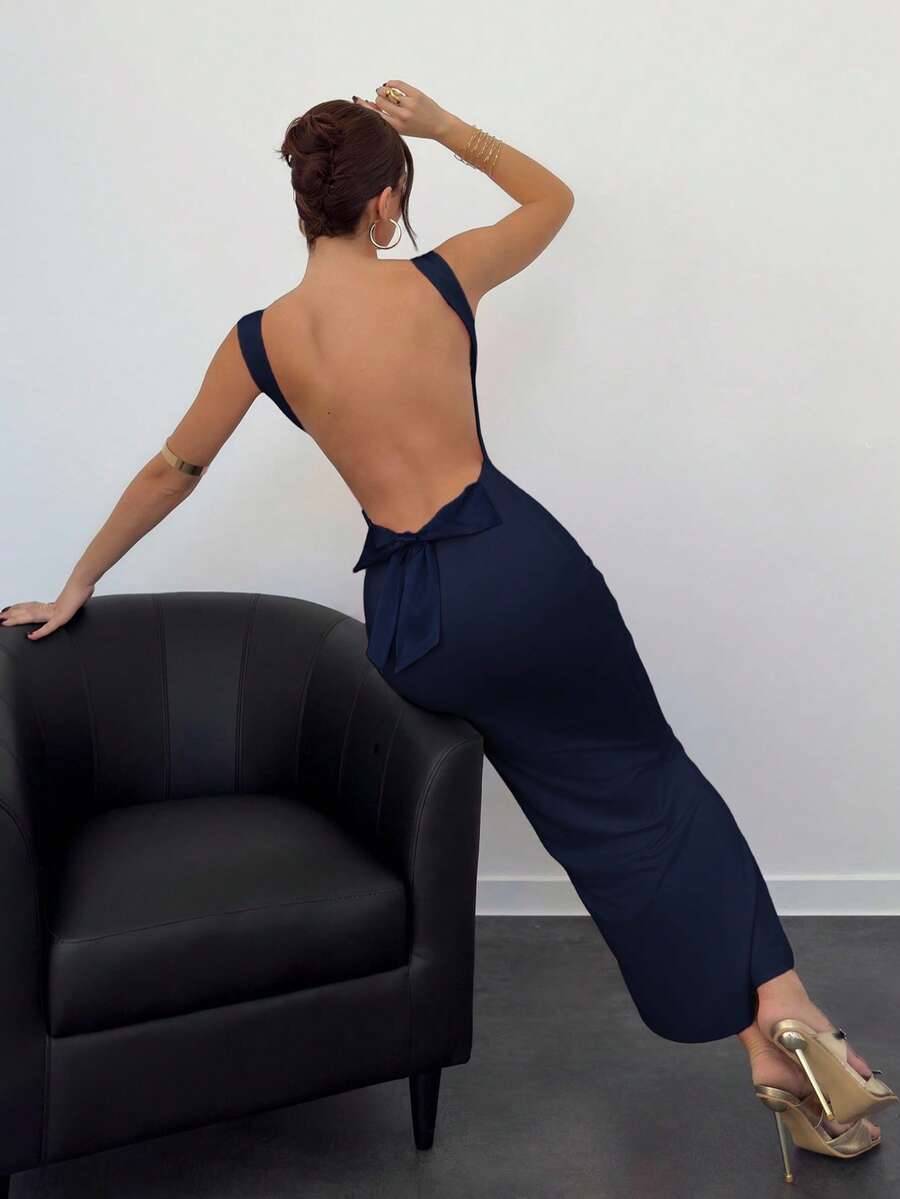 Beige sleeveless backless cami maxi dress for women featuring bow decor, split hem, and slim fit knitted fabric.