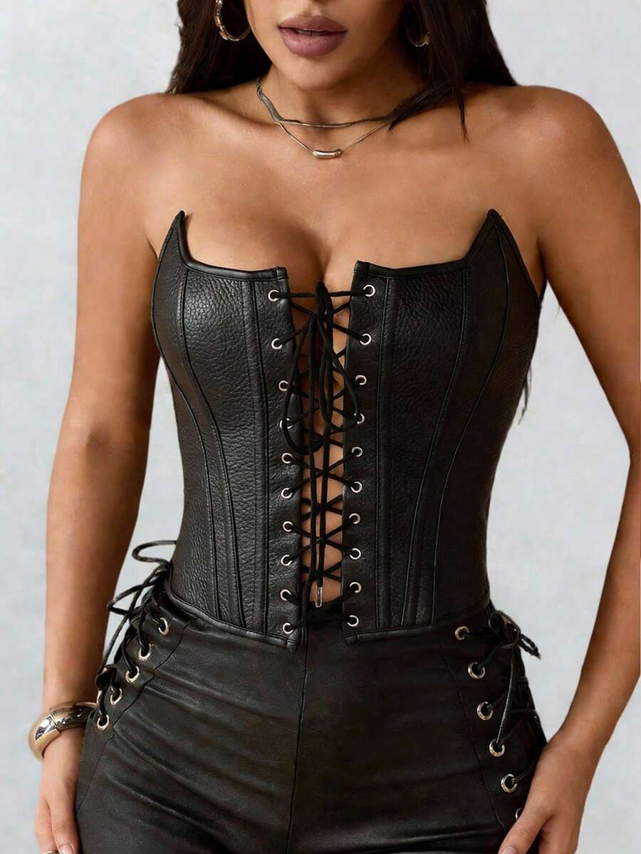 Black PU leather strapless bustier corset crop top featuring boned structure, lace-up grommet eyelets, and an asymmetrical hem on a women model.