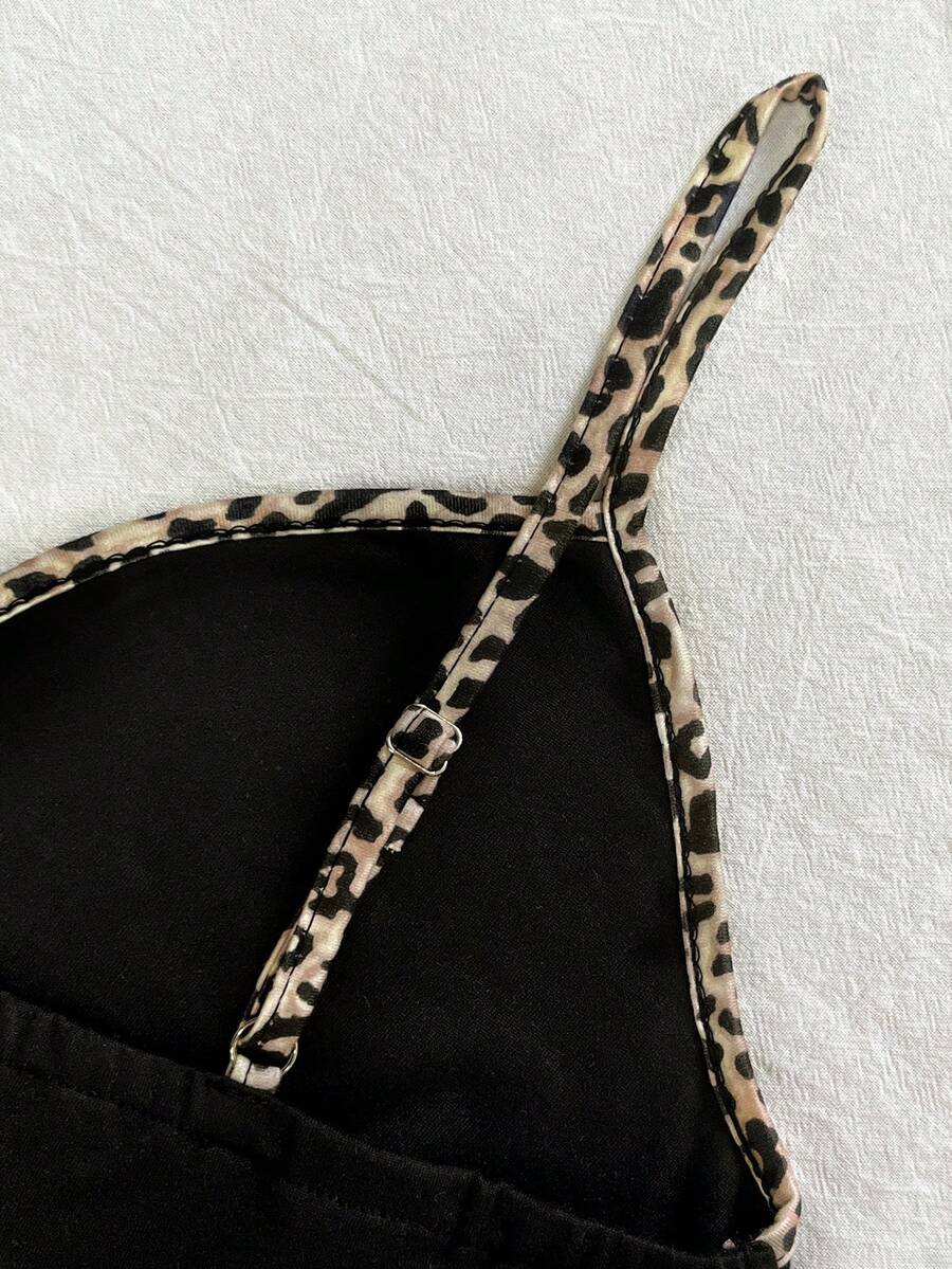 A women's solid slim fit camisole top with delicate contrast lace trim around the neckline and spaghetti straps.