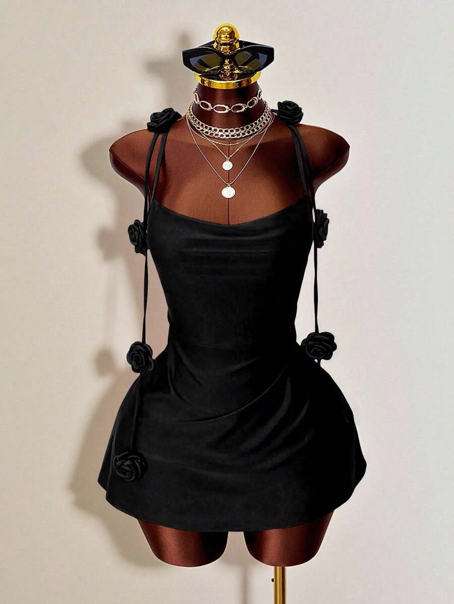 Women's bodycon mini dress featuring a 3D rose accent, thin spaghetti straps, and an open back design.