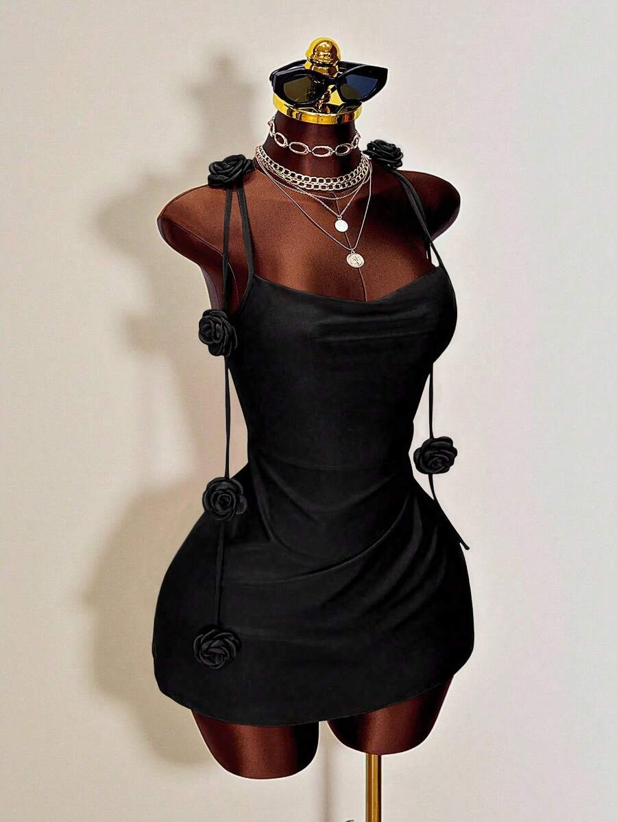 Women's bodycon mini dress featuring a 3D rose accent, thin spaghetti straps, and an open back design.
