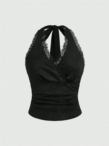 Women's black fitted halter neck camisole featuring contrast lace details, a V-neckline, knot detail, and backless design.