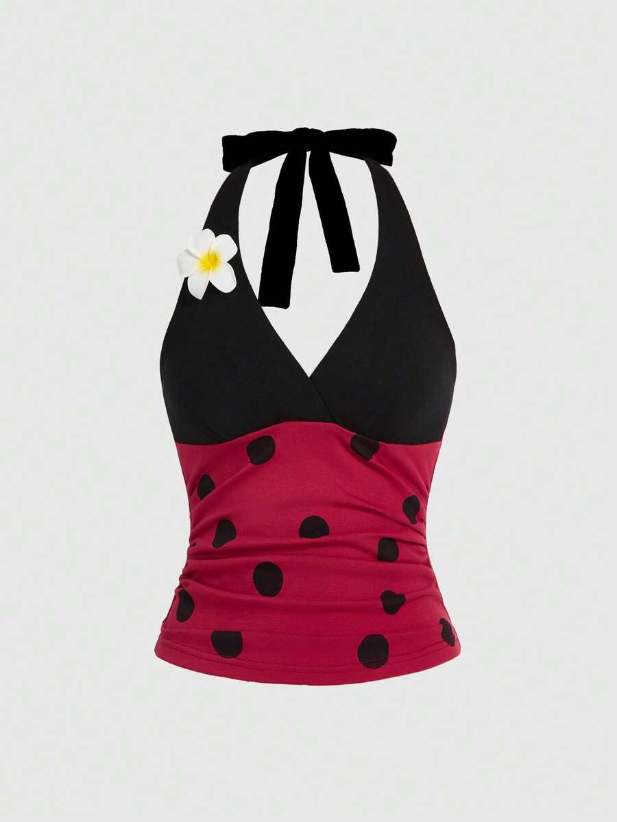 Black and white polka dot halter neck tank top featuring a backless design with ruched knot details and daisy accent.