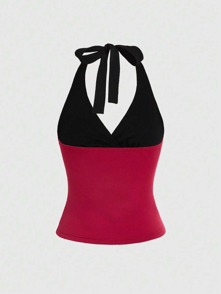Black and white polka dot halter neck tank top featuring a backless design with ruched knot details and daisy accent.