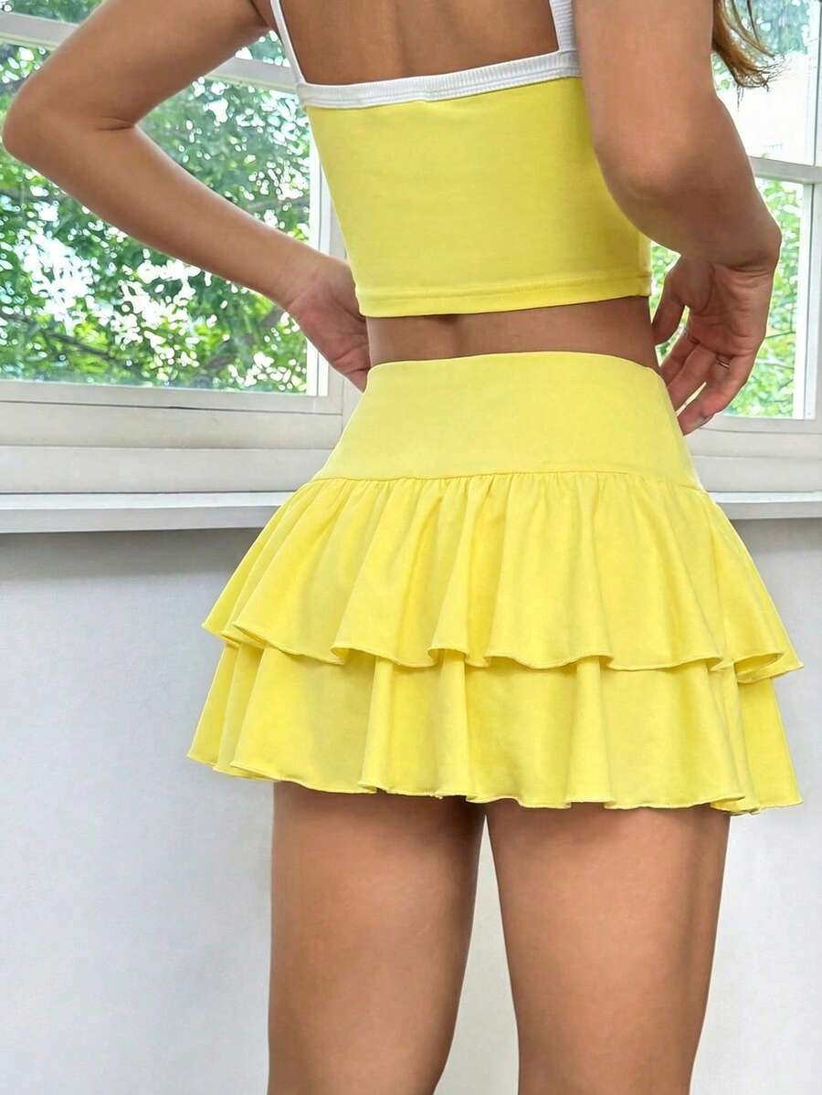 Black low waist knit mini skirt featuring a tiered ruffle hem and skinny high stretch fit.