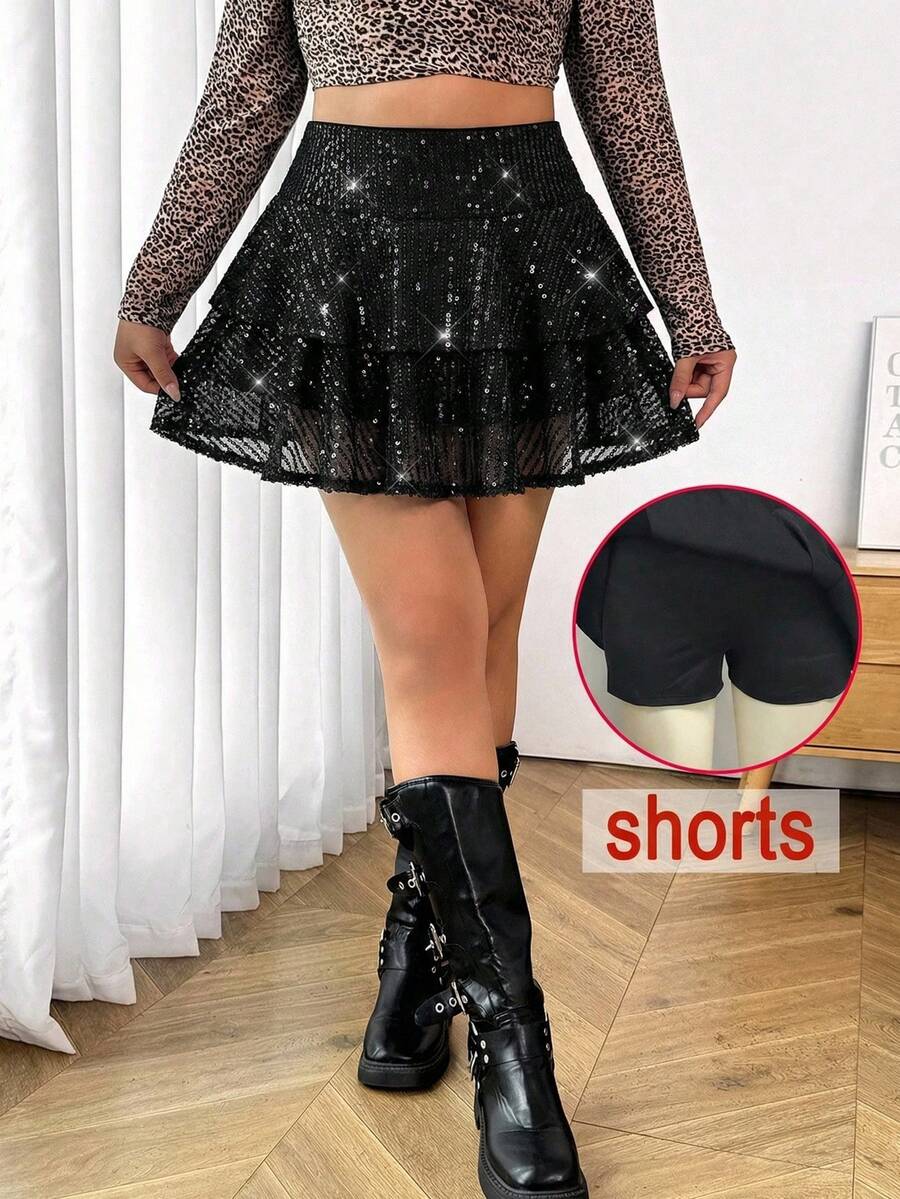 Tween girl wearing a casual black sequin tiered cake skirt featuring contrast mesh layers and a ruched drawstring mid waist.