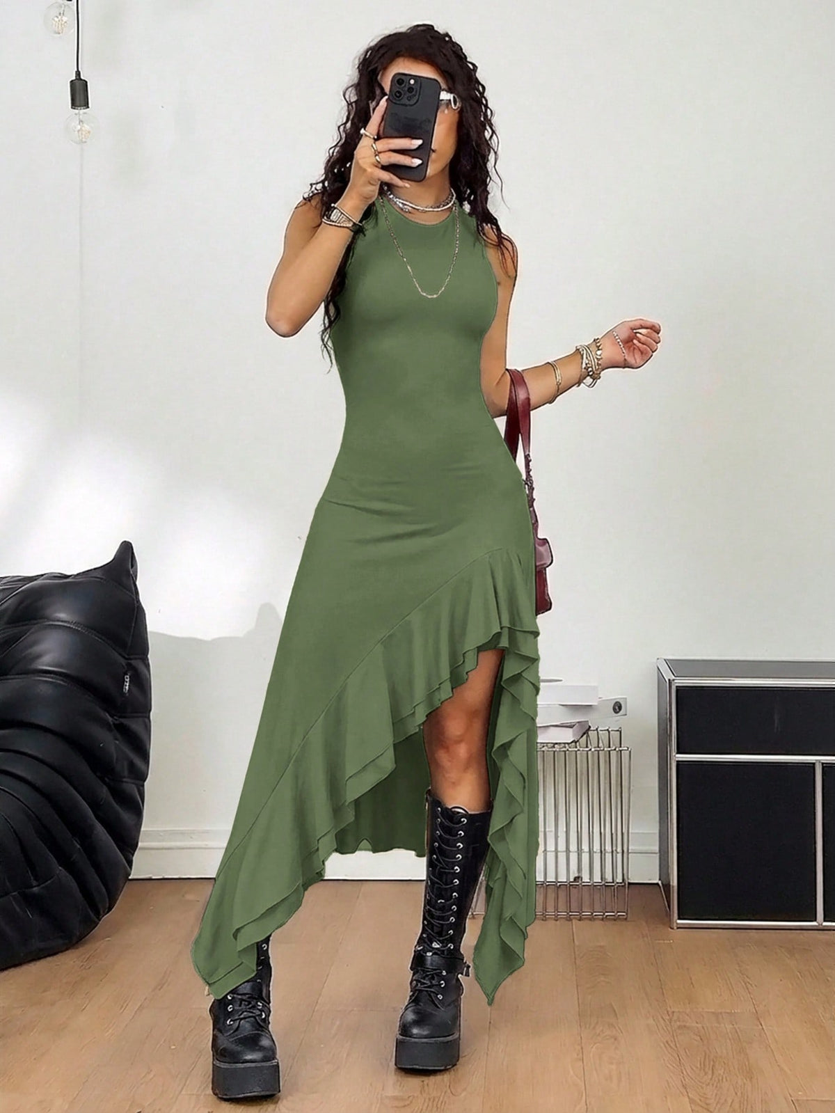 Women wearing a sleeveless army green long dress with a round neck and asymmetrical ruffle hem.