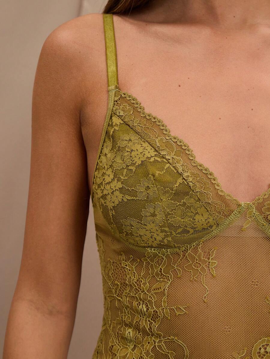 Black floral lace cropped camisole top for women featuring delicate spaghetti straps, cup detail, and semi-sheer contrast lace.