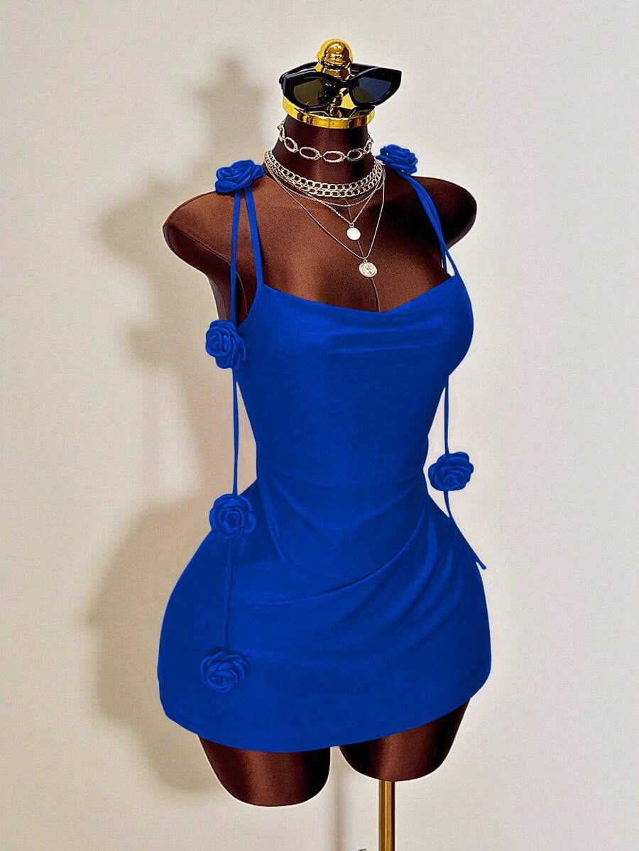 Women's bodycon mini dress featuring a 3D rose accent, thin spaghetti straps, and an open back design.