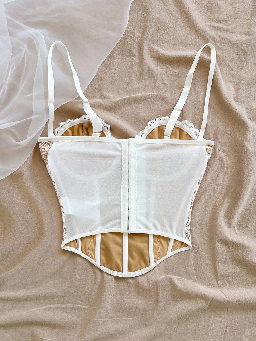 Women's lace bustier camisole top with spaghetti straps, contrast lace, lace-up detail, and an asymmetrical hem in a slim fit design.