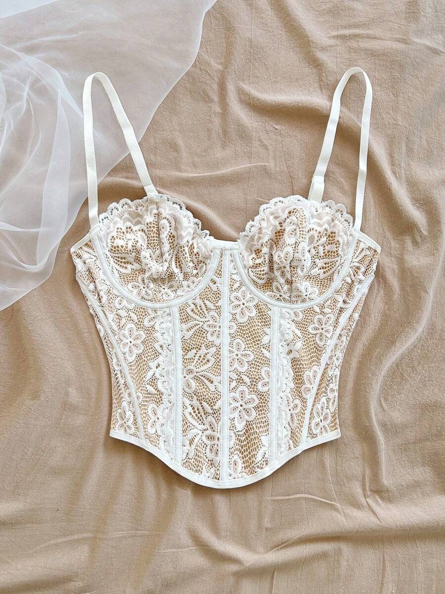 Women's lace bustier camisole top with spaghetti straps, contrast lace, lace-up detail, and an asymmetrical hem in a slim fit design.