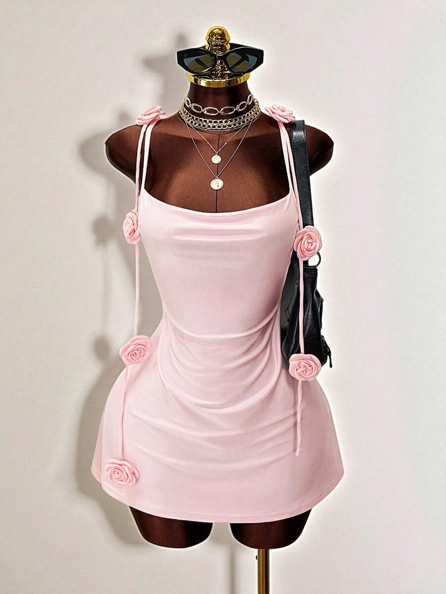 Women's bodycon mini dress featuring a 3D rose accent, thin spaghetti straps, and an open back design.
