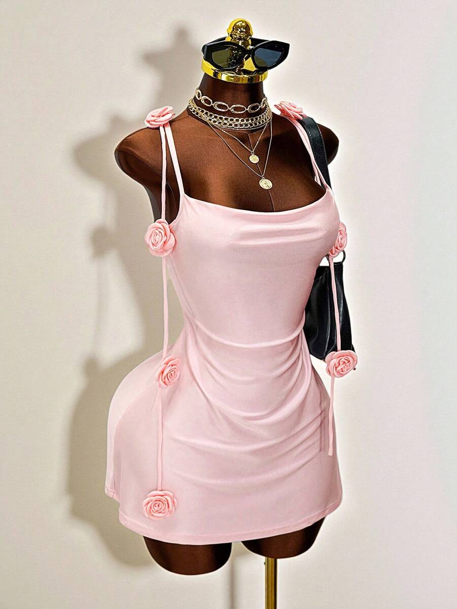 Women's bodycon mini dress featuring a 3D rose accent, thin spaghetti straps, and an open back design.