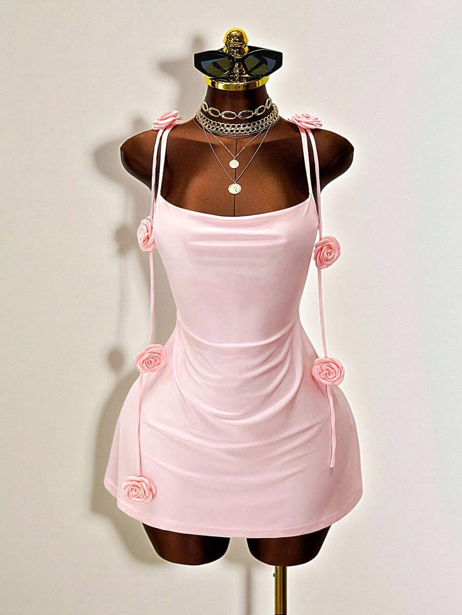 Women's bodycon mini dress featuring a 3D rose accent, thin spaghetti straps, and an open back design.