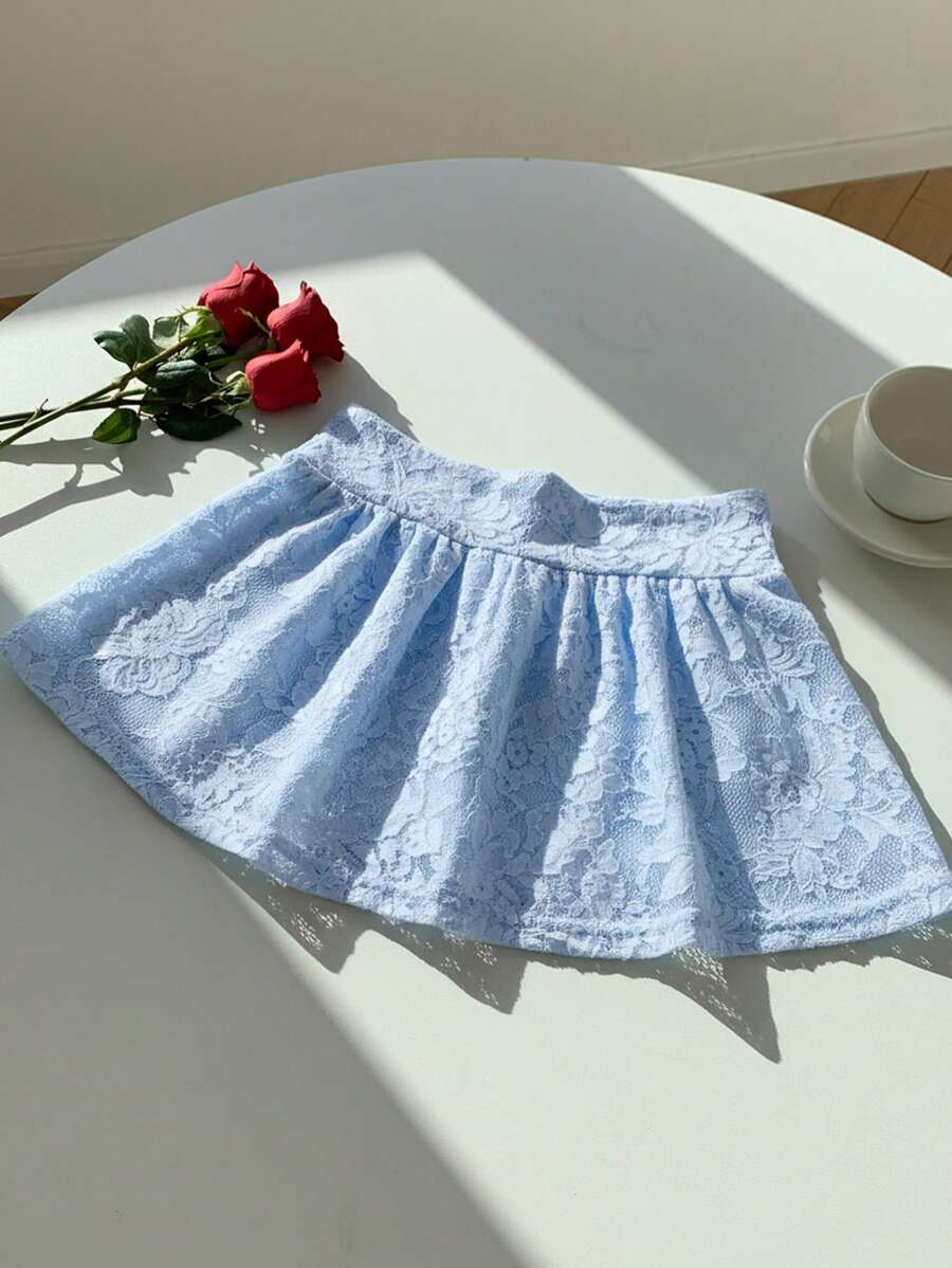 Women's black semi-sheer knitted lace mini skirt featuring a flared ruffle hem and low waist design