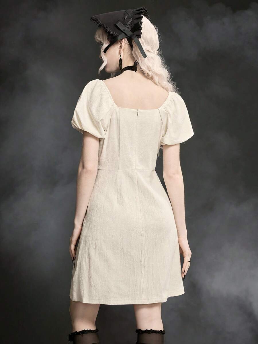 White Goth mini skater dress for women featuring dark skull graphic print, square neckline, short puff sleeves, and lace-up detail.