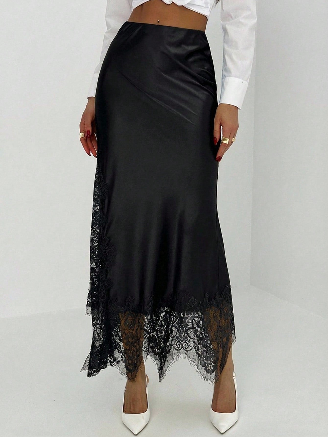 Women's elegant black lace patchwork mermaid maxi skirt featuring asymmetrical contrast lace design and low waist fit.