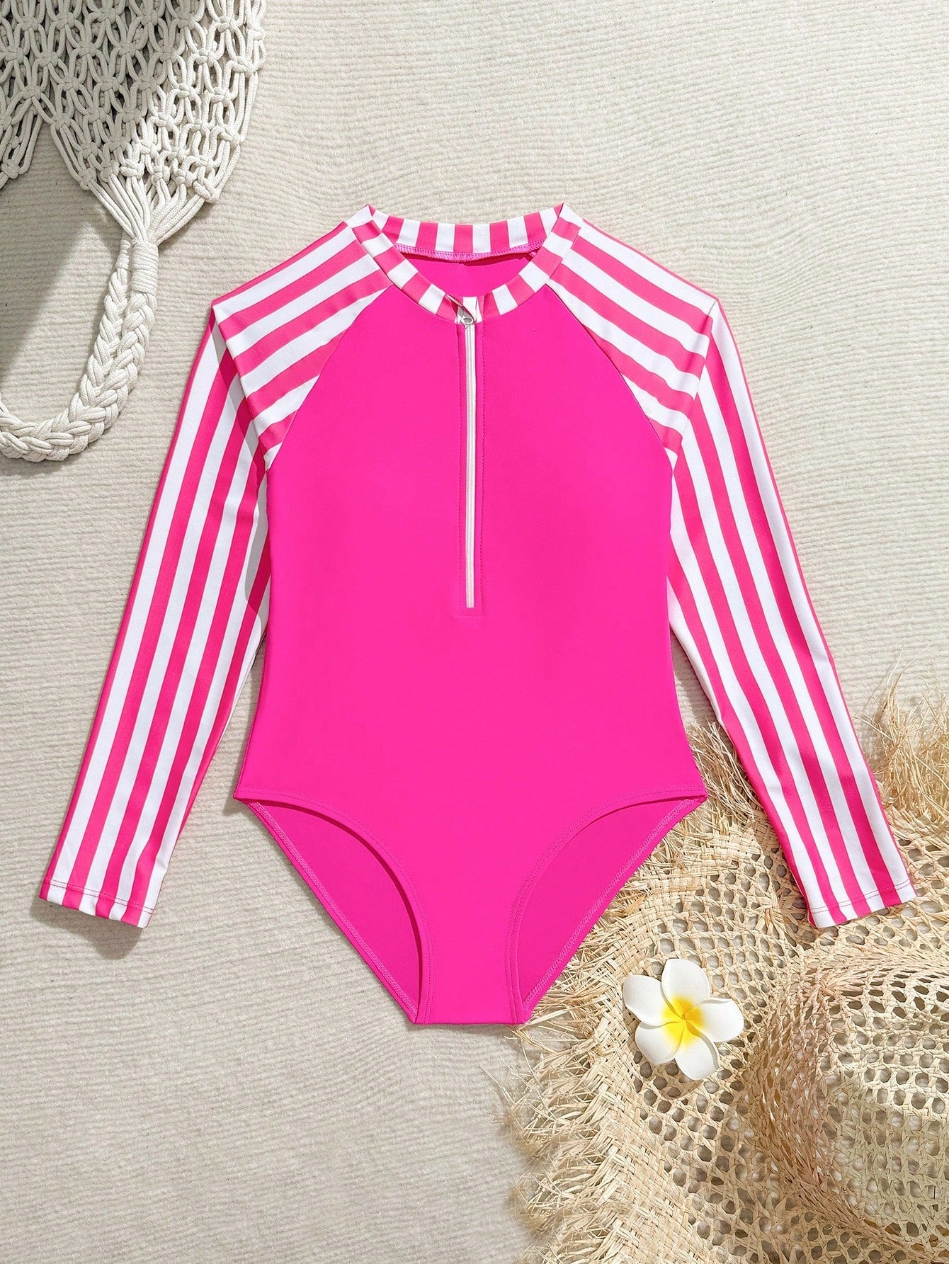 Tween girls one-piece rash guard swimsuit with long sleeves, high neck, front zipper, and ocean shell graphic print in a fitted style for beach, swimming, and vacation wear.