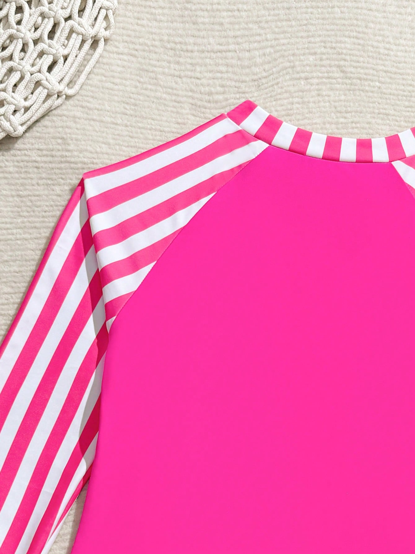 Tween girls one-piece rash guard swimsuit with long sleeves, high neck, front zipper, and ocean shell graphic print in a fitted style for beach, swimming, and vacation wear.