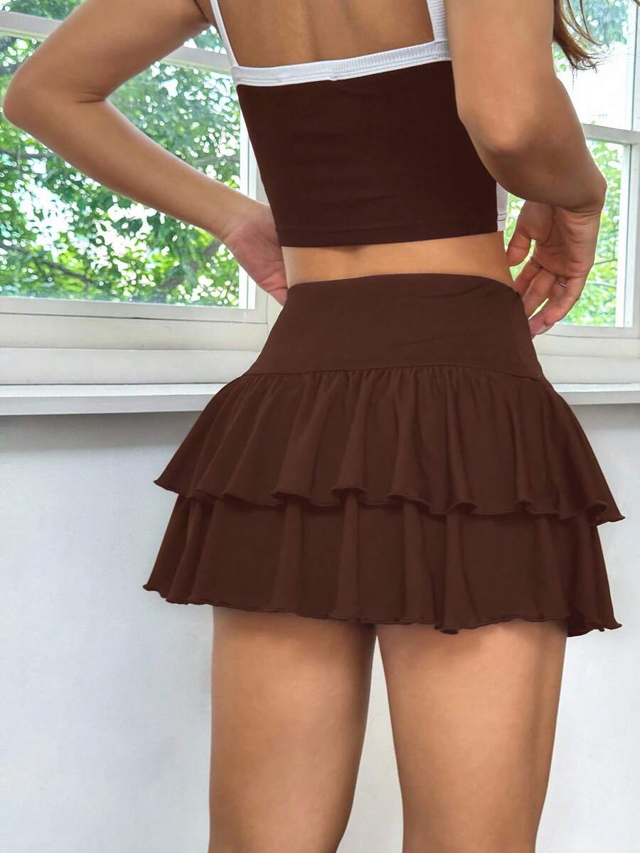 Black low waist knit mini skirt featuring a tiered ruffle hem and skinny high stretch fit.