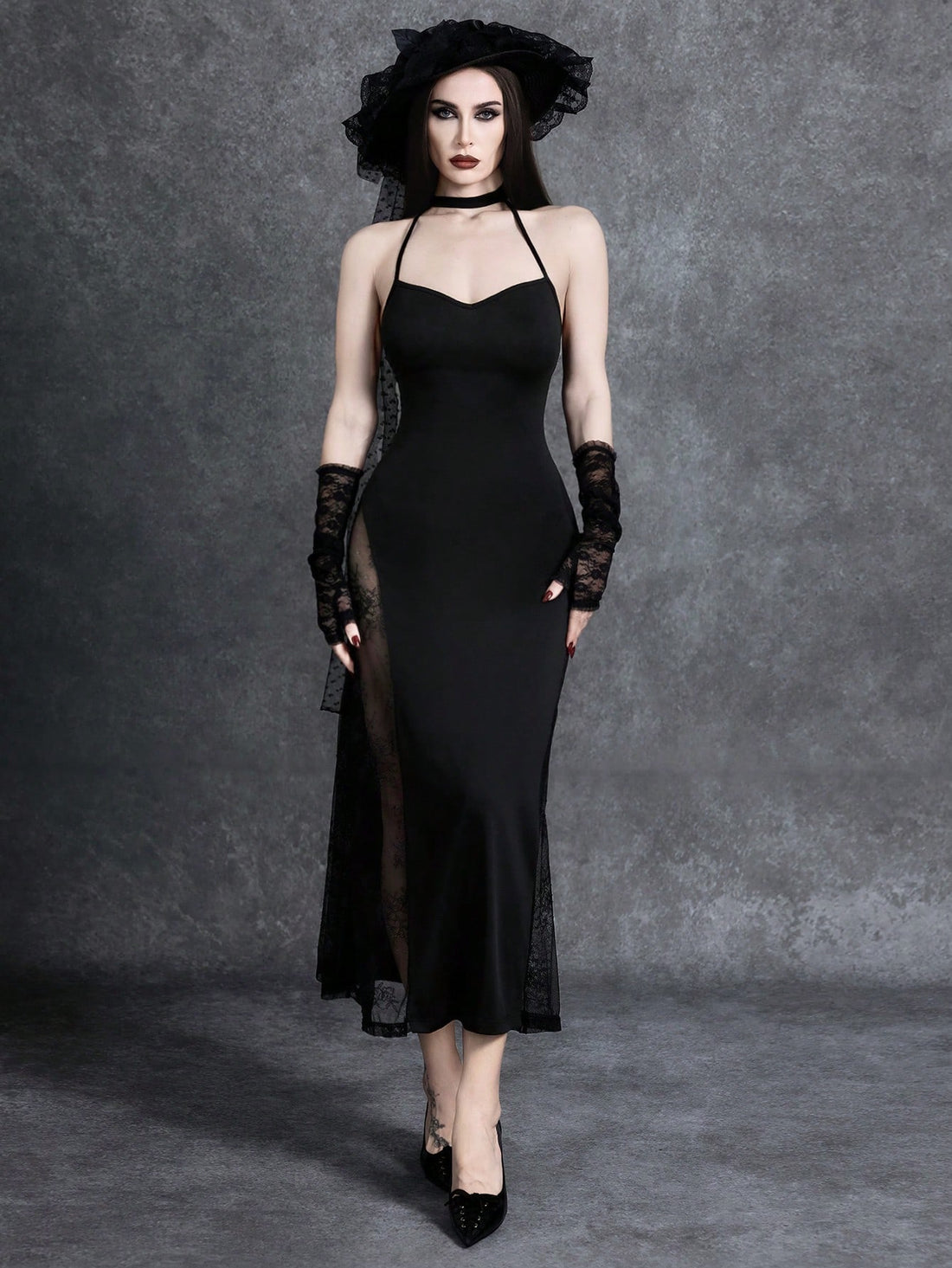 Women's black cami midi dress featuring a halter neckline, backless criss-cross knot design, slim fit silhouette, and mermaid hemline.