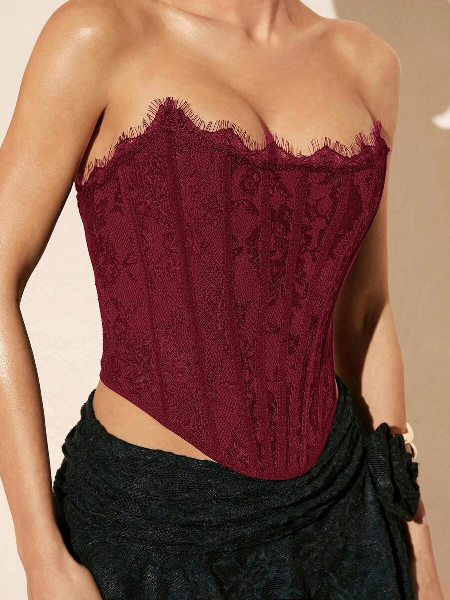 Women's strapless bustier crop top with contrast lace, lace-up detail, and an asymmetric hem in a slim-fit satin finish.