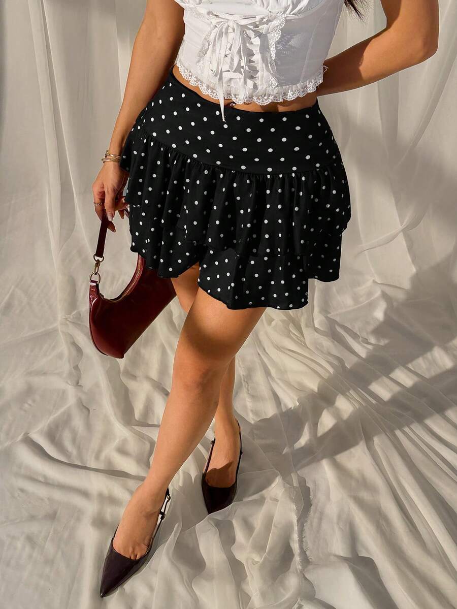 Black low waist knit mini skirt featuring a tiered ruffle hem and skinny high stretch fit.