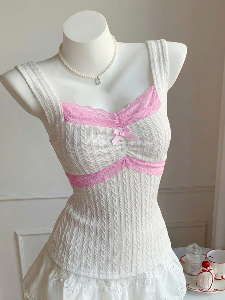 Black and white polka dot knit camisole tank top featuring delicate contrast lace trim, a cute bow accent at the sweetheart neckline, and slender shoulder straps.