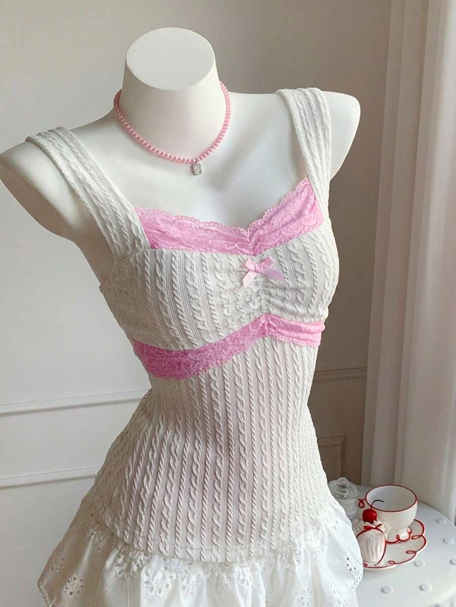 Black and white polka dot knit camisole tank top featuring delicate contrast lace trim, a cute bow accent at the sweetheart neckline, and slender shoulder straps.