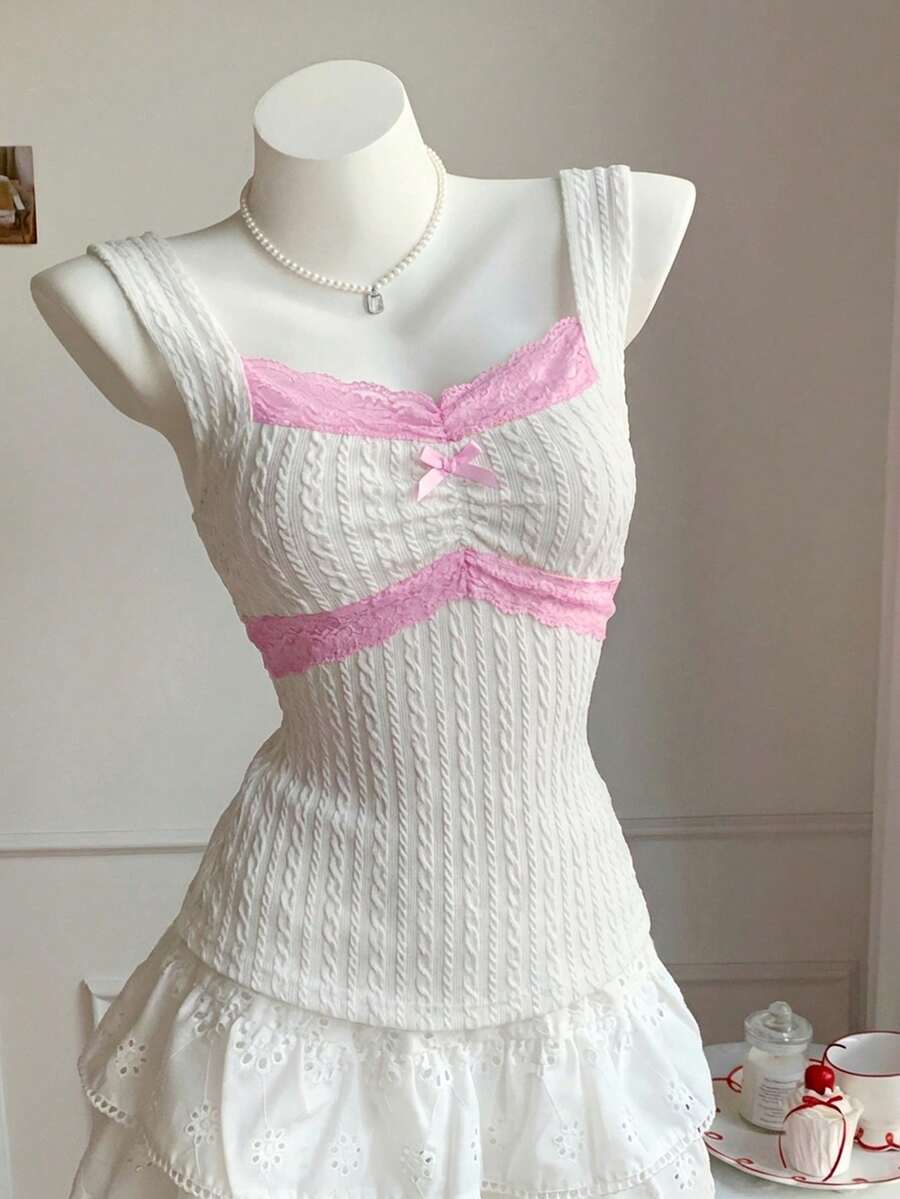 Black and white polka dot knit camisole tank top featuring delicate contrast lace trim, a cute bow accent at the sweetheart neckline, and slender shoulder straps.