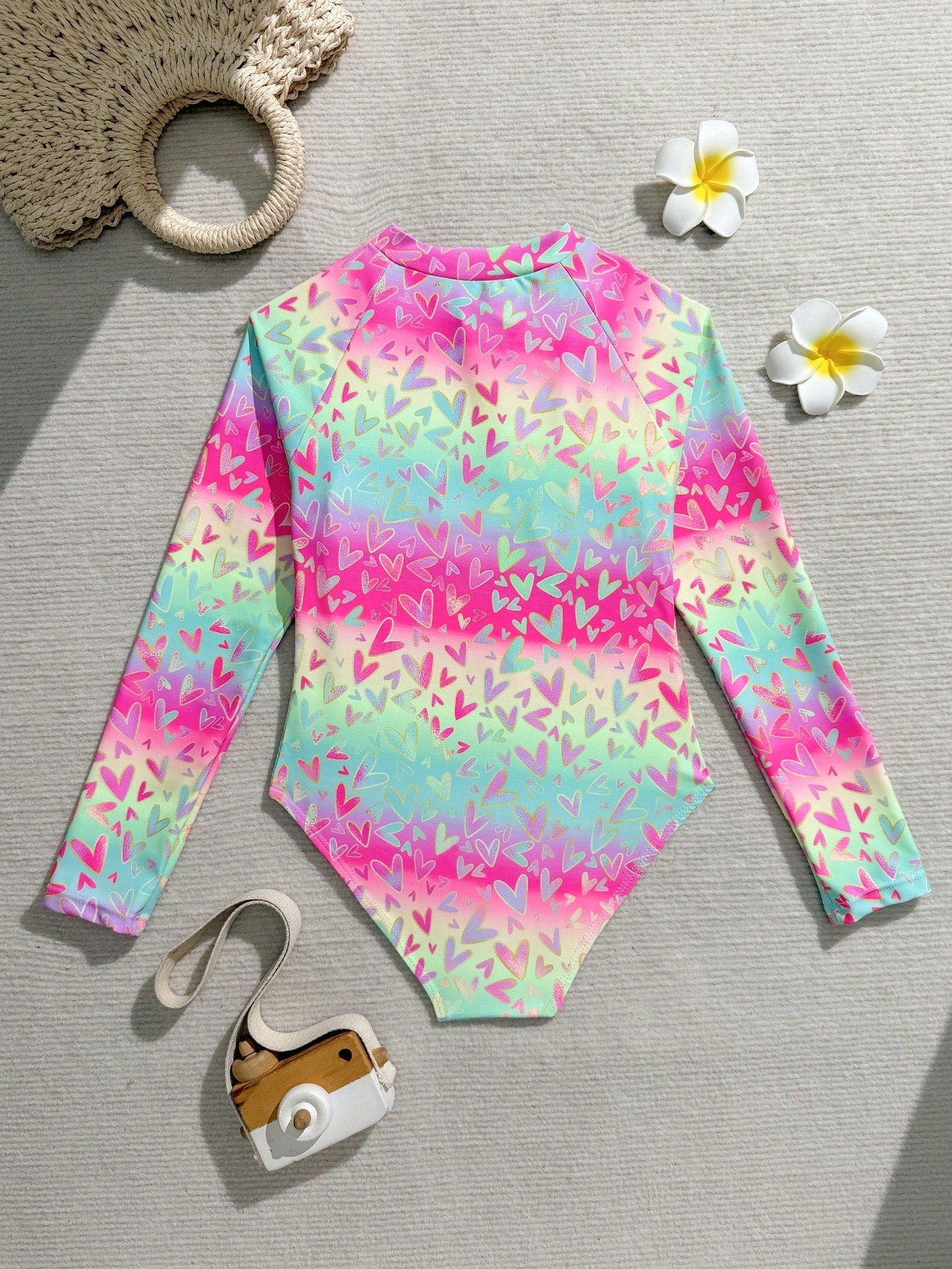 Tween girls one-piece rash guard swimsuit with long sleeves, high neck, front zipper, and ocean shell graphic print in a fitted style for beach, swimming, and vacation wear.