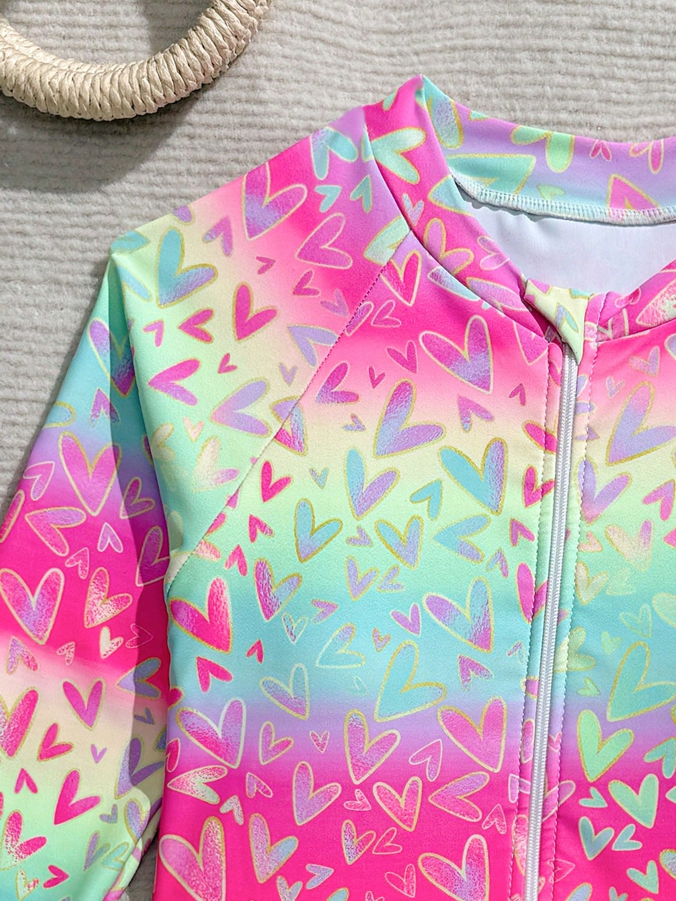 Tween girls one-piece rash guard swimsuit with long sleeves, high neck, front zipper, and ocean shell graphic print in a fitted style for beach, swimming, and vacation wear.