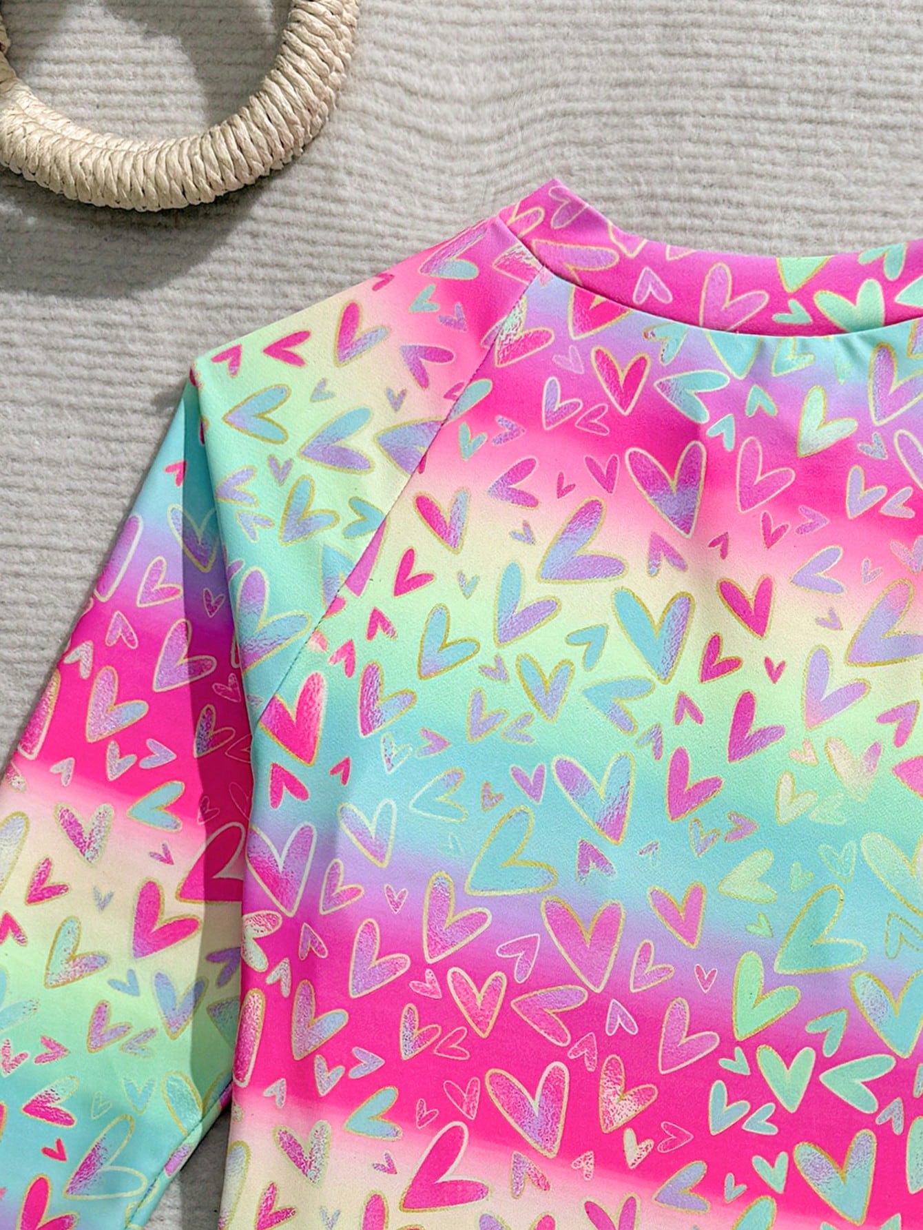 Tween girls one-piece rash guard swimsuit with long sleeves, high neck, front zipper, and ocean shell graphic print in a fitted style for beach, swimming, and vacation wear.