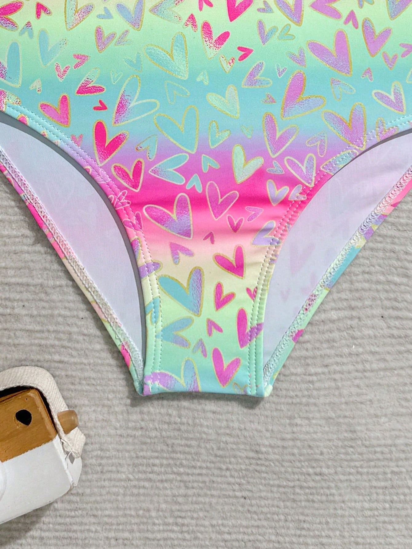 Tween girls one-piece rash guard swimsuit with long sleeves, high neck, front zipper, and ocean shell graphic print in a fitted style for beach, swimming, and vacation wear.