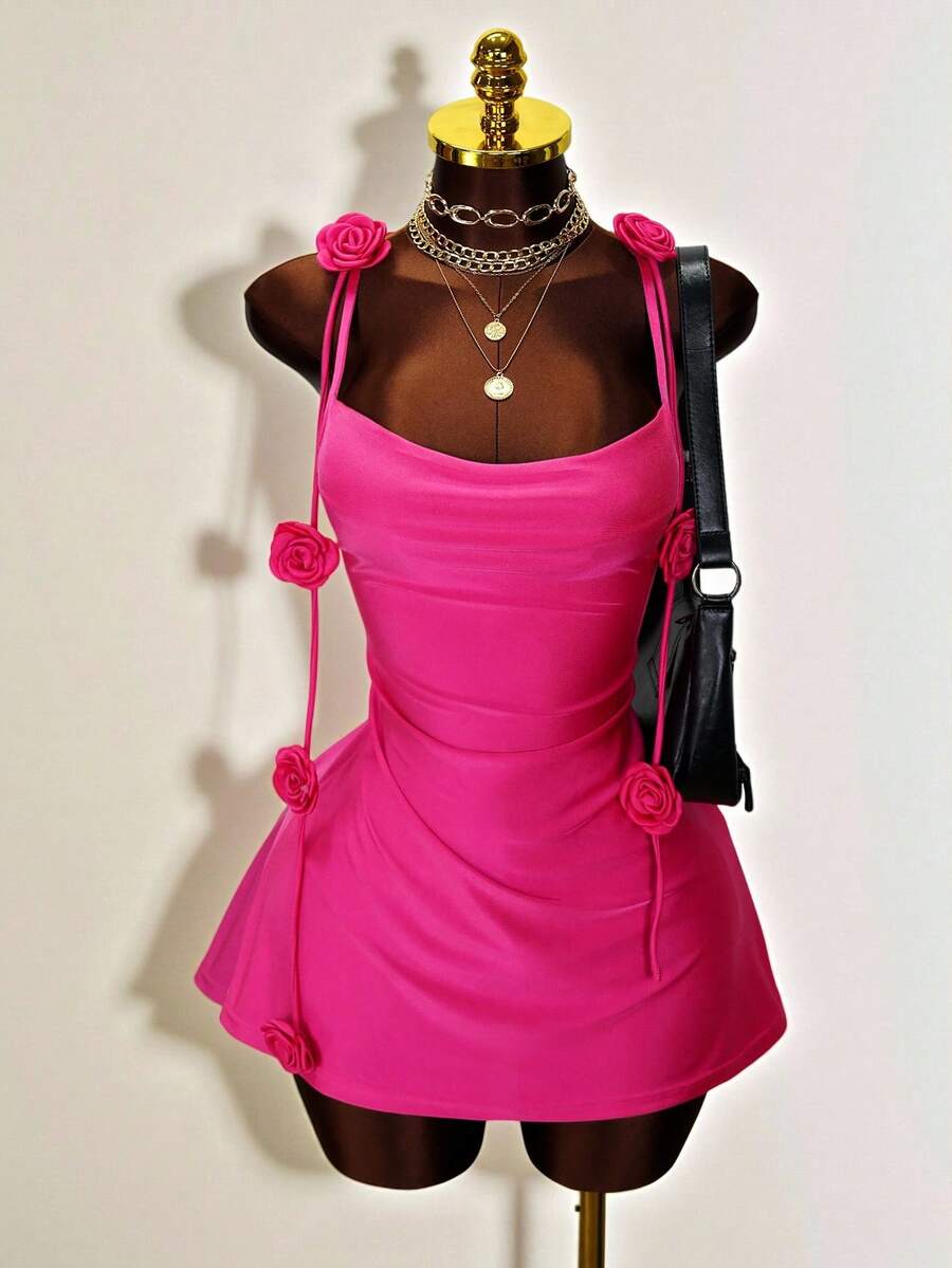 Women's bodycon mini dress featuring a 3D rose accent, thin spaghetti straps, and an open back design.