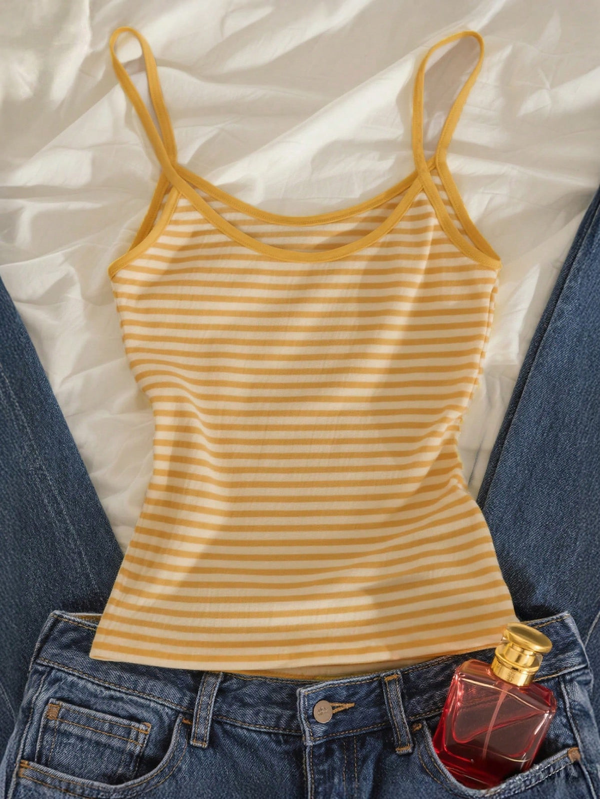 Women's pink striped crop camisole featuring criss cross spaghetti straps and slim fit design.