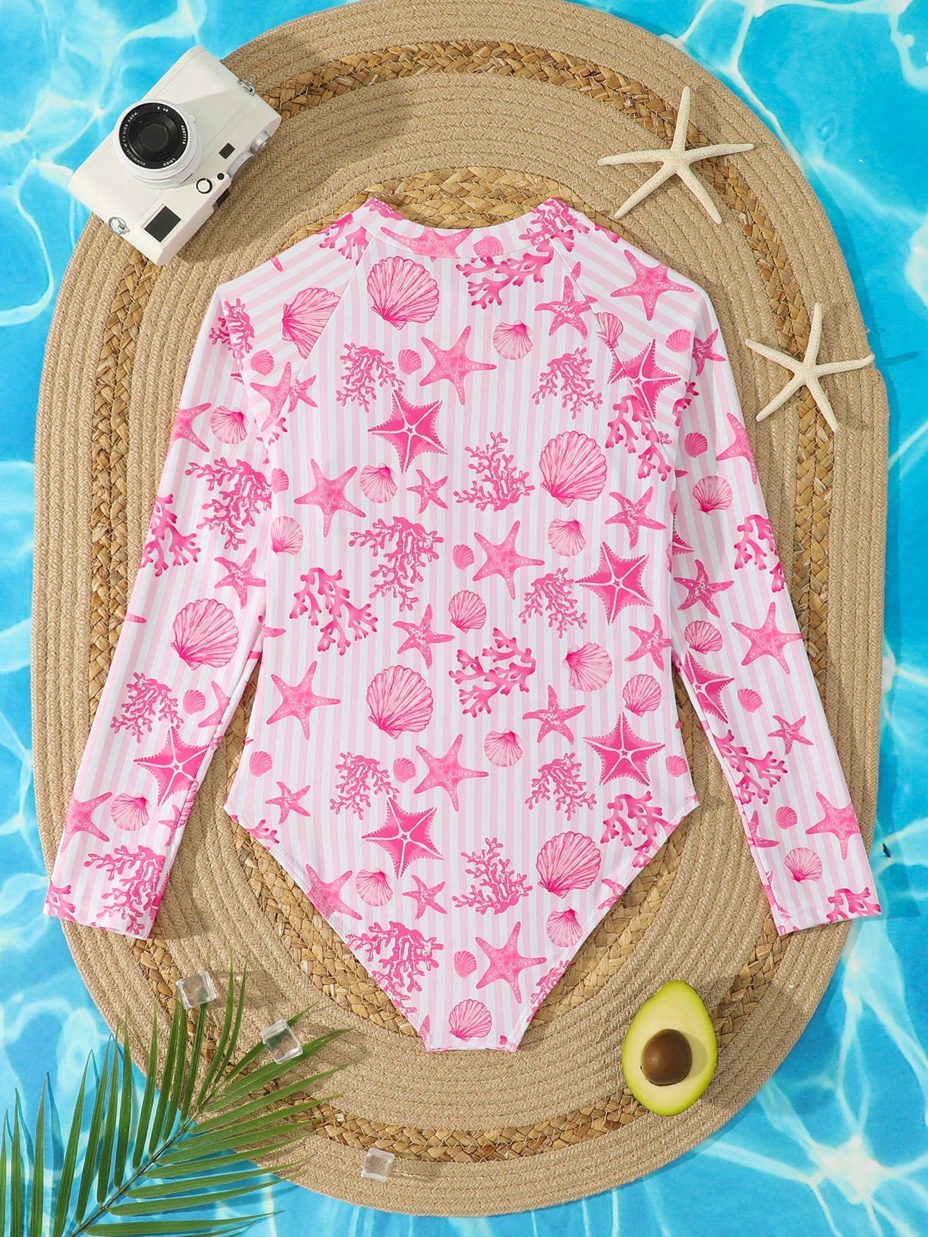 Tween girls one-piece rash guard swimsuit with long sleeves, high neck, front zipper, and ocean shell graphic print in a fitted style for beach, swimming, and vacation wear.