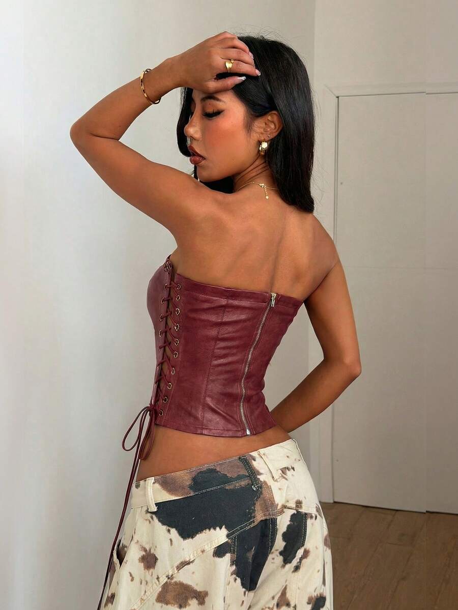 Women’s coffee brown faux leather lace-up crop top with strapless neckline, slit hem, and slim fitted silhouette for festival and nightlife wear.