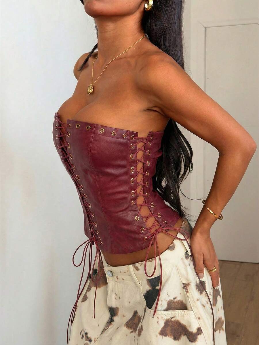 Women’s coffee brown faux leather lace-up crop top with strapless neckline, slit hem, and slim fitted silhouette for festival and nightlife wear.