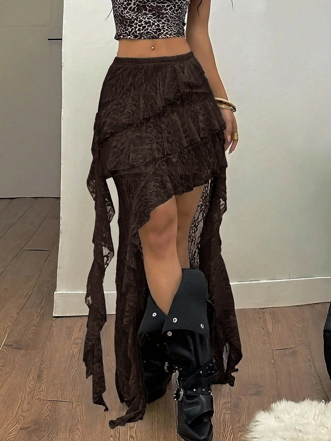 Women's black asymmetrical long skirt with ruffle hem and low waist design in knitted fabric.