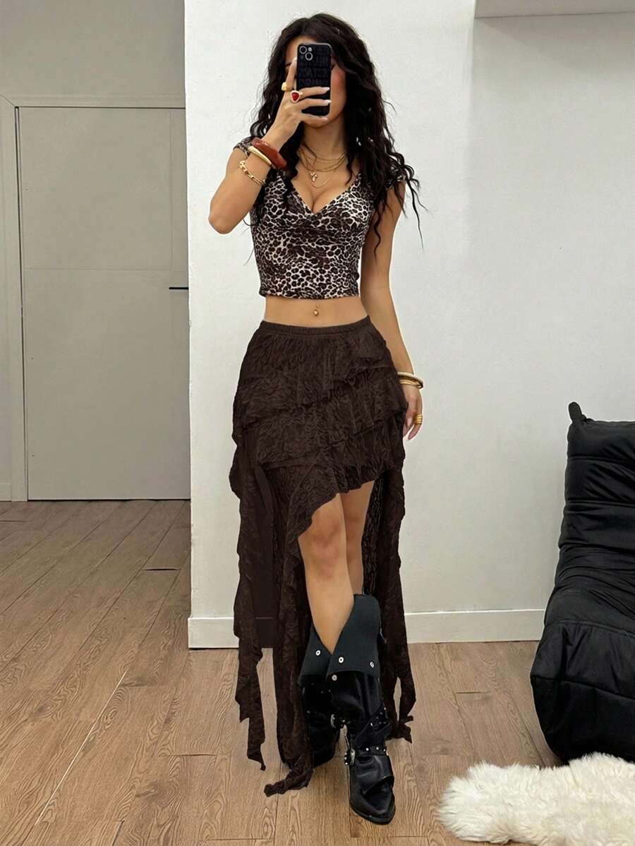 Women's black asymmetrical long skirt with ruffle hem and low waist design in knitted fabric.