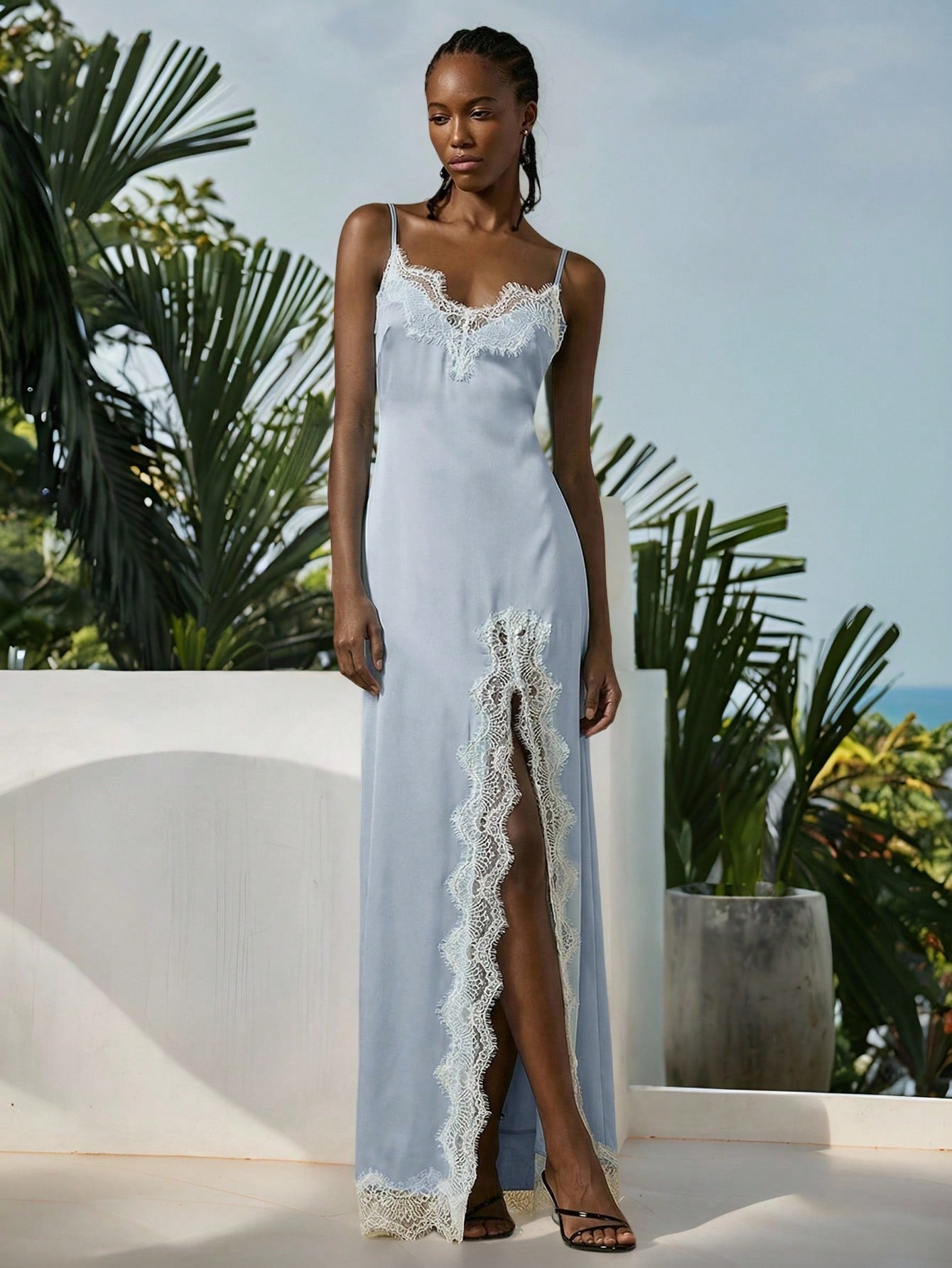 Women's black lace split satin long dress featuring spaghetti straps, asymmetrical slit hem, and matching arm sleeves.