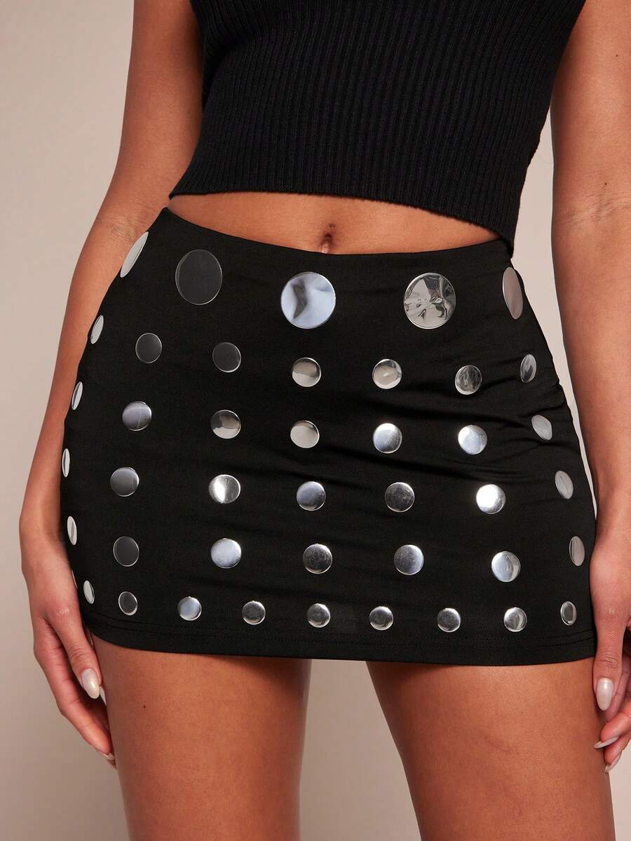 Women's black bodycon mini skort featuring a low waist, pleated side split hem, zipper closure, and built-in shorts.