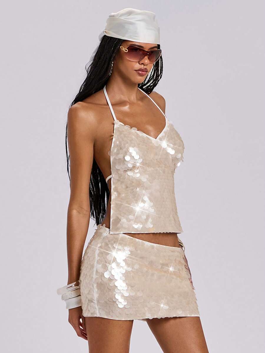 Beige sequin halter camisole crop top for women featuring a backless tie-dye pattern, knot detail, and asymmetrical hem.