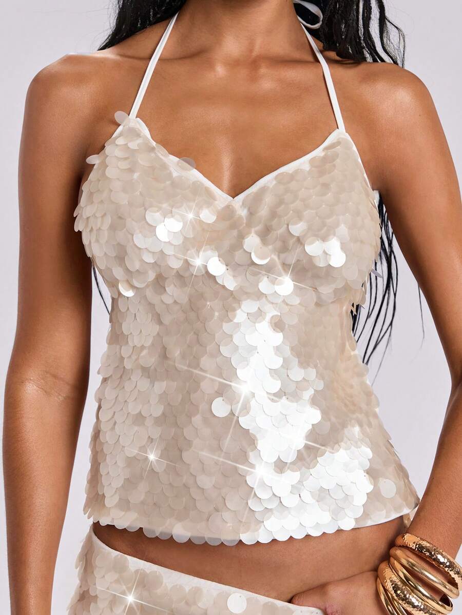 Beige sequin halter camisole crop top for women featuring a backless tie-dye pattern, knot detail, and asymmetrical hem.
