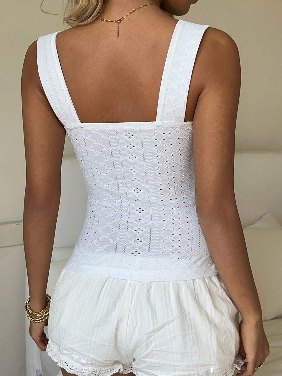 Black and white polka dot knit camisole tank top featuring delicate contrast lace trim, a cute bow accent at the sweetheart neckline, and slender shoulder straps.