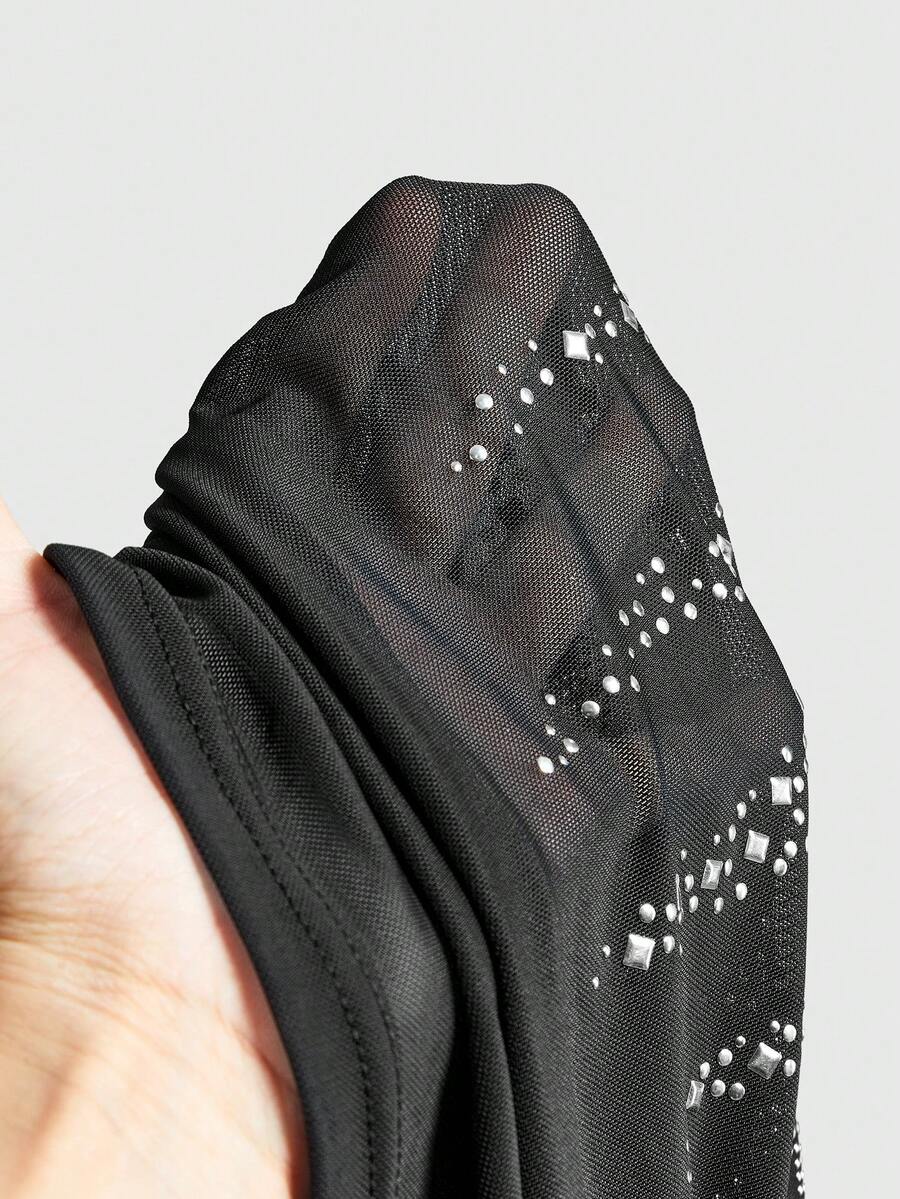 Women's black sheer mesh crop cami top with sparkling rhinestone embellishments, ruched detailing, and thin spaghetti straps.